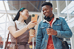 photo of 2 young Gen Z age people looking at a smartphone screen