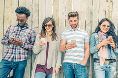 photo of a group of young adults looking at their smartphones