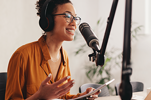 podcasts photo of a male in a recording studio with headphones on talking into a microphone