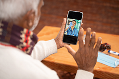 photo of a senior individual during a virtual healthcare visit on his smartphone