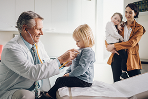 Podium article guide image photo of a physician examining a young child in an exam room
