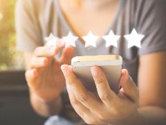 photo of a person holding a smarthphone with 5 stars imposed over the phone, as in Star rating